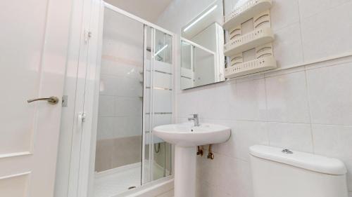 a white bathroom with a sink and a shower at Holidoo Travel Casa Dorada in Los Alcázares