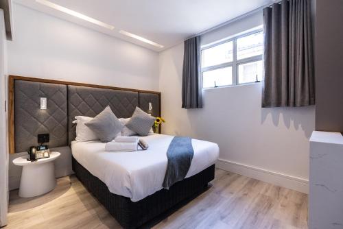 a bedroom with a large bed and a window at Cape Diamond Boutique Hotel in Cape Town