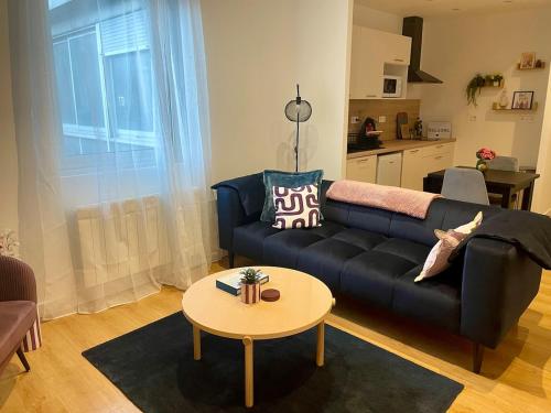 un salon avec un canapé noir et une table dans l'établissement Chic and Relaxing Retreat with Air Con, Bath Ritual & Candles - Pets welcome, à Carcassonne