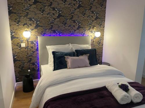 une chambre avec un grand lit avec un éclairage violet dans l'établissement Chic and Relaxing Retreat with Air Con, Bath Ritual & Candles - Pets welcome, à Carcassonne
