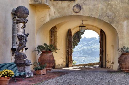 an archway with an entrance to a building with flowers at Agriturismo La Fattoria di Capezzana in Carmignano