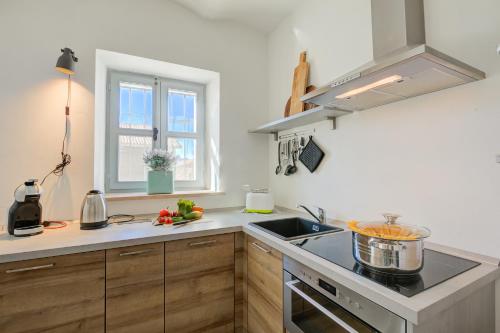 a kitchen with a sink and a stove top oven at In Bocca Al Lupo with Shared Pool in Clavesana