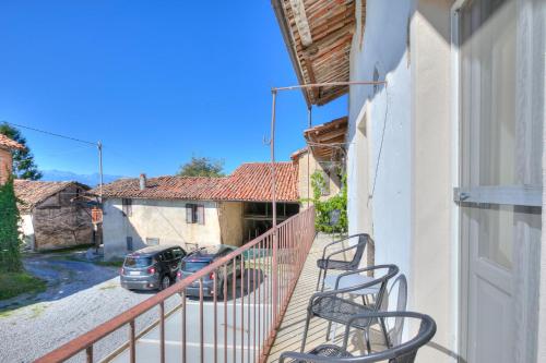 a balcony with chairs and a car parked on a street at In Bocca Al Lupo with Shared Pool in Clavesana