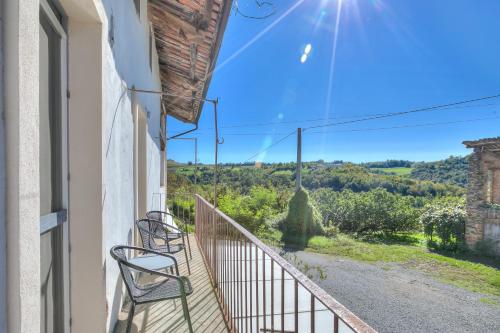 a balcony with chairs and a view of the countryside at In Bocca Al Lupo with Shared Pool in Clavesana