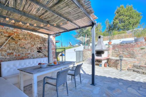 a patio with a table and chairs and an outdoor oven at In Bocca Al Lupo with Shared Pool in Clavesana