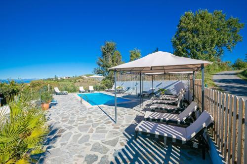 a group of chairs under an umbrella next to a pool at In Bocca Al Lupo with Shared Pool in Clavesana
