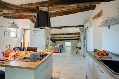 a kitchen and living room with wooden ceilings at In Bocca Al Lupo with Shared Pool in Clavesana