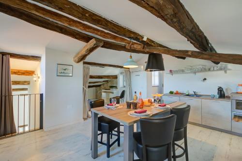 a kitchen and dining room with a wooden table and chairs at In Bocca Al Lupo with Shared Pool in Clavesana