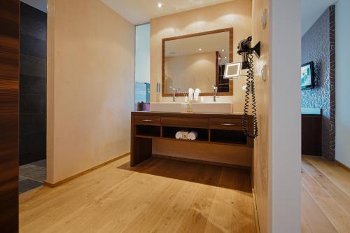 a bathroom with a sink and a mirror at Das Kronthaler - Adults only in Achenkirch