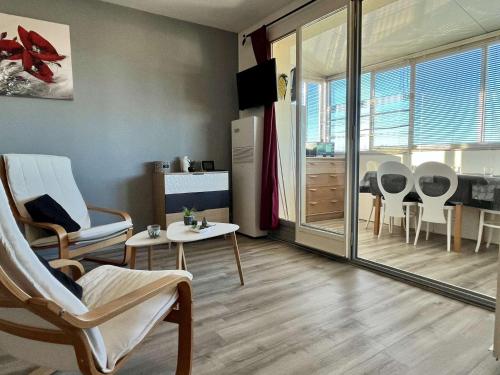 un salon avec des chaises et une table et une cuisine dans l'établissement Appartement Studio 4 couchages ARGELES SUR MER AR850-118, à Argelès-sur-Mer