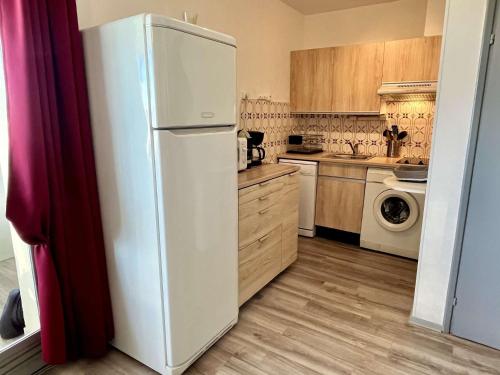 - un réfrigérateur blanc dans une cuisine avec des placards en bois dans l'établissement Appartement Studio 4 couchages ARGELES SUR MER AR850-118, à Argelès-sur-Mer