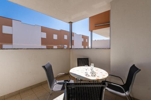 a table and chairs in a room with a large window at Apartment Village Nin in Nin