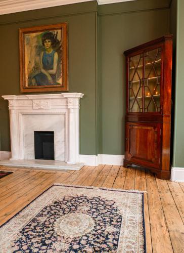 a living room with a fireplace and a painting on the wall at Rothay Garth in Ambleside