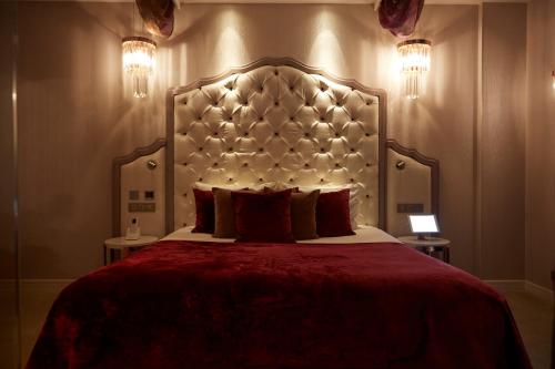 a bedroom with a large bed with a large headboard at Paris j'Adore Hotel & Spa in Paris
