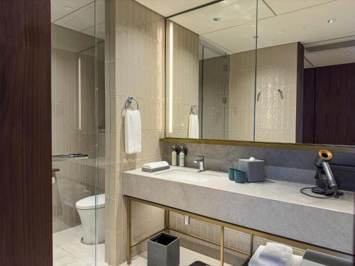a bathroom with a sink and a toilet and a mirror at New World Guangzhou Hotel-- FREE Canton Fair Shuttle Bus in Guangzhou