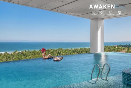 a woman sitting on a raft in a swimming pool at Awaken Da Nang Hotel in Danang
