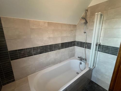 une salle de bain avec baignoire et douche dans l'établissement Proche Plage LÉGENÈSE - 1143, à Carnac