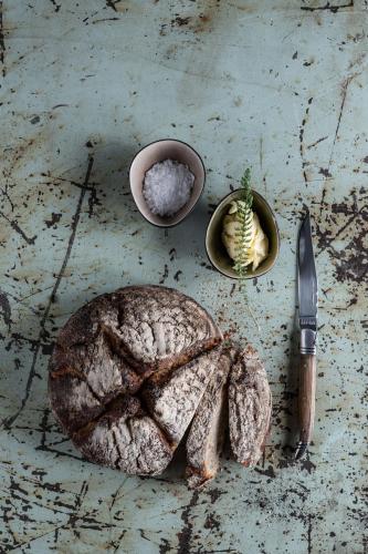a loaf of bread and a knife on a table at Bio-Landhotel Moarwirt in Dietramszell