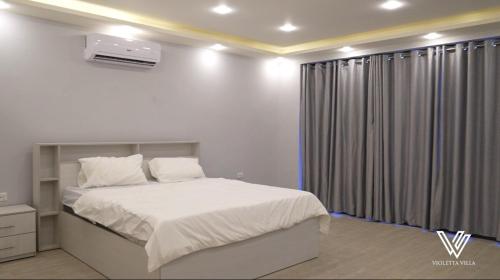 a bedroom with a white bed and a window at Violetta Villa Chalet in Madaba
