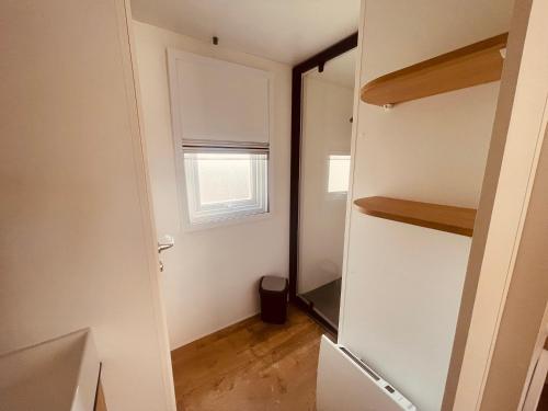 Cette petite chambre dispose d'un placard et d'une fenêtre. dans l'établissement Mobil Home Oliviers 3, à Valras-Plage