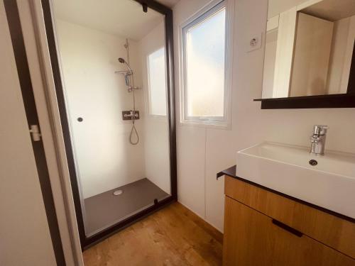 une salle de bain avec une douche, un lavabo et un miroir dans l'établissement Mobil Home Oliviers 3, à Valras-Plage