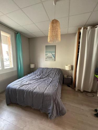 une chambre avec un lit et un lustre dans l'établissement Agréable maison de ville, à Perpignan