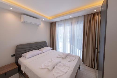 a bedroom with a bed and a large window at Calis Suites Çeşme - Only Family in Cesme