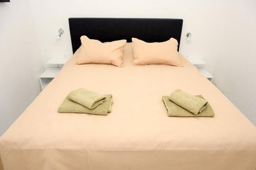 - un lit avec 2 oreillers et 2 serviettes dans l'établissement Apartman Leo Jajce, à Jajce