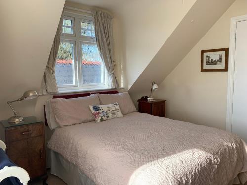 a bedroom with a bed and a window at Heatherdene House in Wimborne Minster