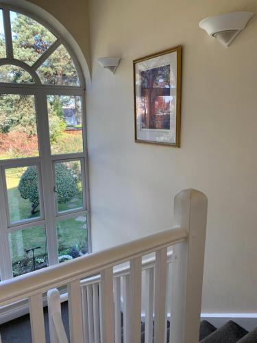 a staircase with an arched window and a picture on the wall at Heatherdene House in Wimborne Minster