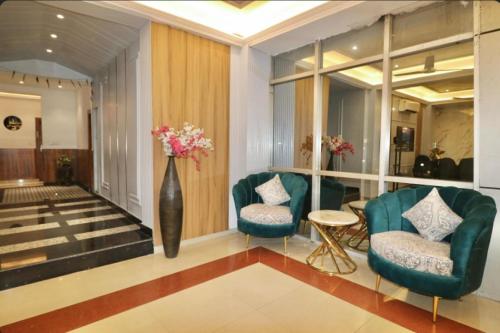 a lobby with two chairs and a vase with flowers at Grand Legacy Beacon, Dehradun in Dehradun