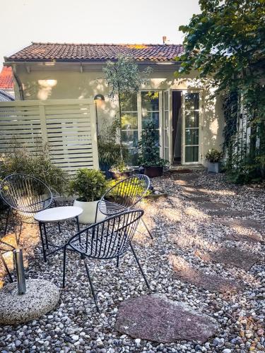 a patio with chairs and a table in front of a house at Modern Guest House Downtown Ystad in Ystad