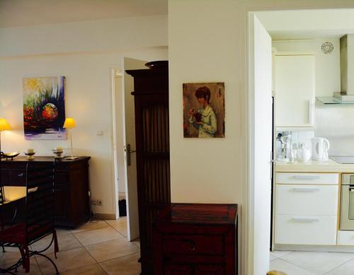 Cette chambre dispose d'une cuisine avec une table et un tableau mural. dans l'établissement Appartement 2 chambres terrasse 100m Croisette, à Cannes