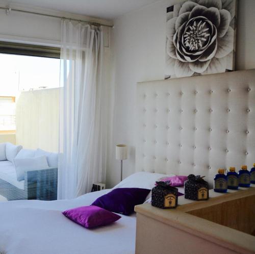- une chambre avec un lit blanc et des oreillers violets dans l'établissement Appartement 2 chambres terrasse 100m Croisette, à Cannes