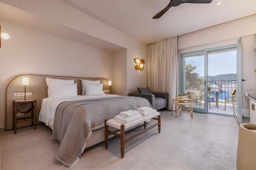 a bedroom with a large bed and a balcony at Minnŏ Boutique Hotel & Spa in Skopelos Town