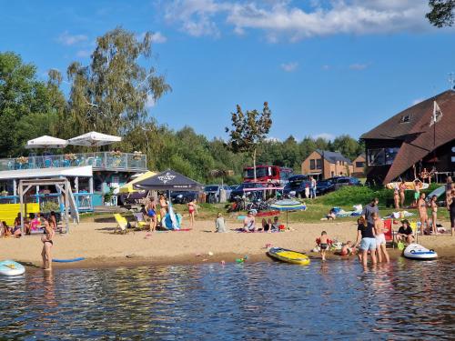 a group of people on a beach near the water at Relax Vila Lipno 2 u pláže Windy Point in Černá v Pošumaví