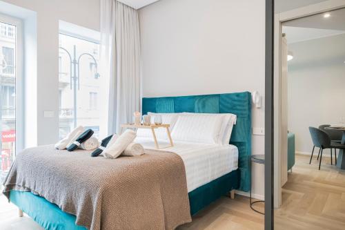 a bedroom with a bed with a blue headboard at Easylife - Duomo Deluxe Apartments #5-11 in Milan