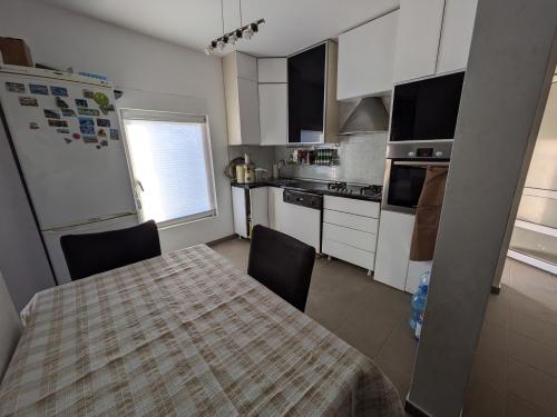 a kitchen with a table and chairs and a refrigerator at Vila Restart Čortanovci in Čortanovci