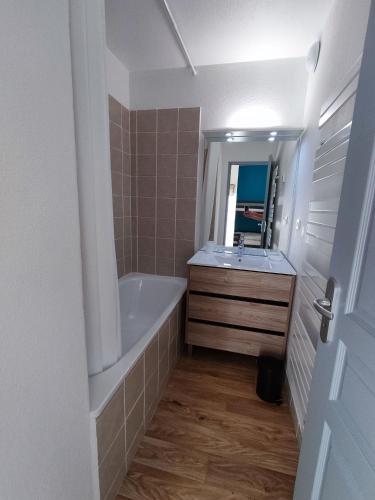 une salle de bain avec une baignoire, un lavabo et un miroir dans l'établissement Mountain Retreat in Hautes-Alpes with Stunning Views, à Orcières