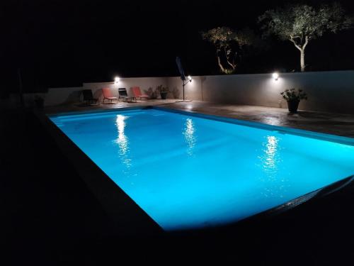 une piscine la nuit avec un éclairage bleu dans l'établissement Close to Saint-Rémy-de-Provence, à Eyragues