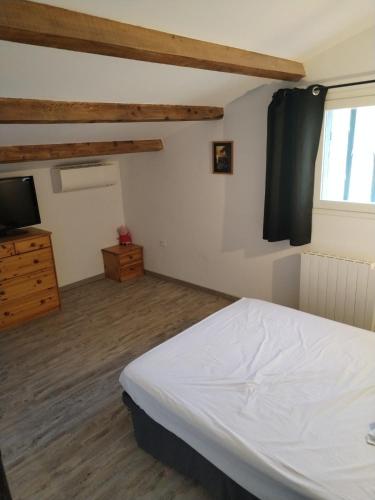 une chambre avec un lit blanc et une télévision dans l'établissement Close to Saint-Rémy-de-Provence, à Eyragues