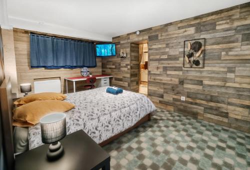 a bedroom with a bed and a table with a lamp at Double Studio Dijon CHU, Cinéma, Jardin & Parking in Dijon