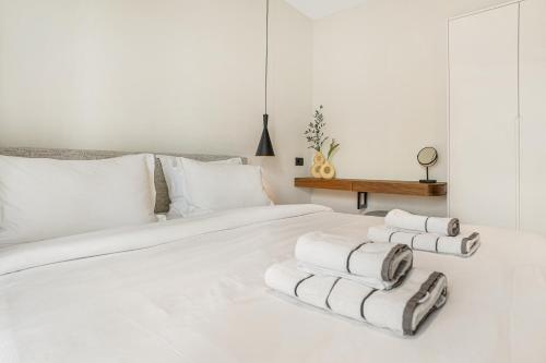 アギオス・ニコラオスにあるUrban Height Suitesの白いベッド(タオルを積み重ねて置いてある)