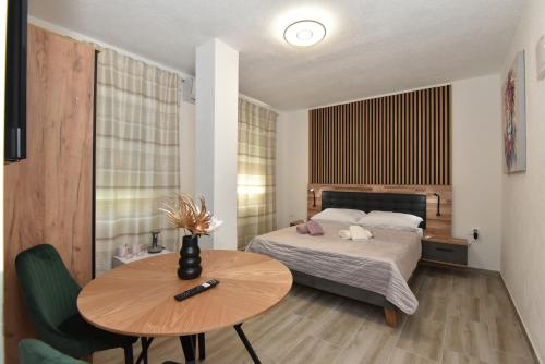 a small bedroom with a bed and a table at SOFIA'S Studio & Room in Zadar