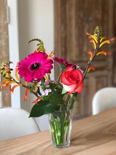 a vase of flowers sitting on a table at Studio Den Burg in Den Burg