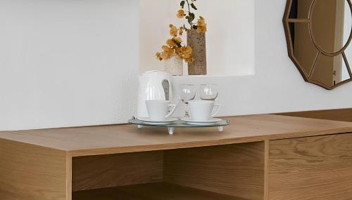 a wooden table with two glasses and a mirror at Santorini Princess Spa Hotel in Imerovigli