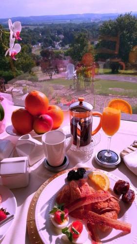 a table with a plate of food on a table with orange juice at The Inn at Dresden in Dresden