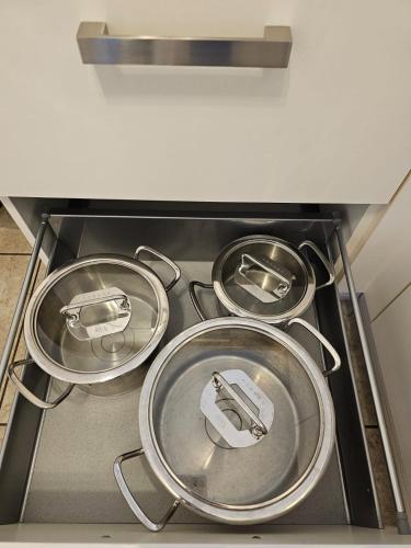 four pans sitting on top of a stove in a kitchen at EcoCube 141 - Terrasse, 3Zimmer, Waschmaschine, Backofen, 5Pers in Meppen