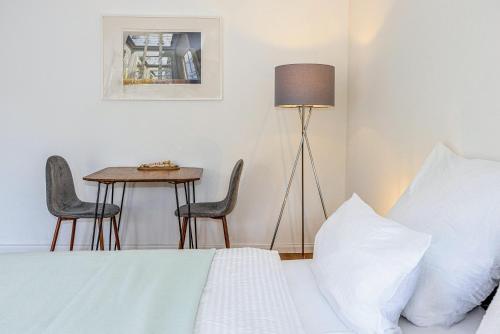 a bedroom with a bed and a table with chairs at have-a-nice-Stay - nahe Bahnhof - 20 Minuten nach Hamburg - trotzdem ruhig gelegen - 6 Minuten zu Fuß ins Zentrum Ahrensburg - modern eingerichtet in Ahrensburg