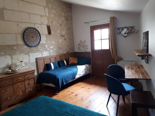 a bedroom with a bed and a table and chairs at LOGÉVEIL - Maison d'hôtes ''Charme et Bien-être'' - proche forêt et golf in Baugé-en-Anjou